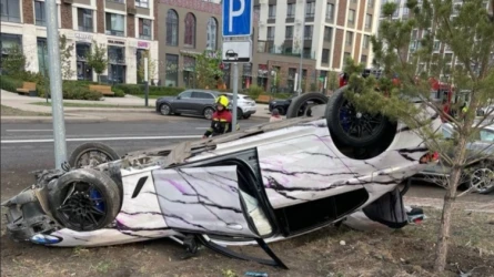BMW перевернулся после наезда на бордюр и столкновения с опорой освещения в Астане